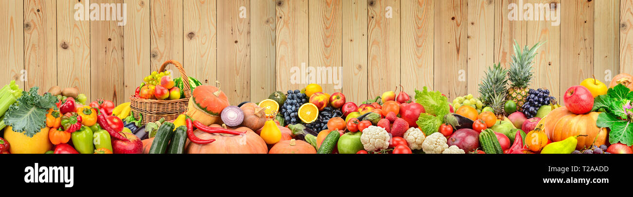 Panoramic photo healthy vegetables and fruits against light wooden wall. Free space for text. Stock Photo