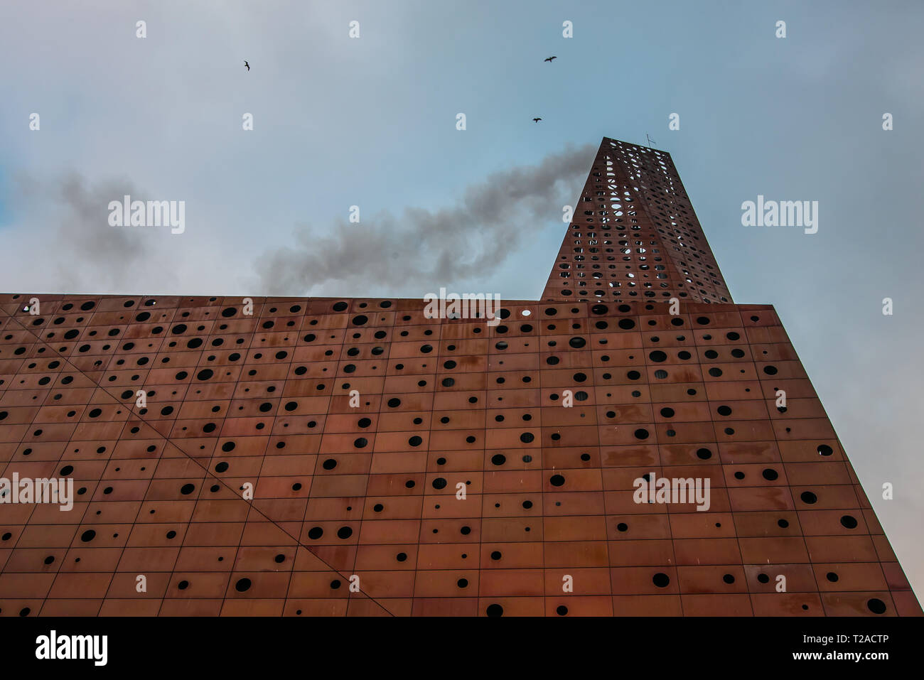 trash-to-energy plant with black smoke along its chimney, the Roskilde Plant,  a thermal power plant in Denmark, March 21, 2019 Stock Photo