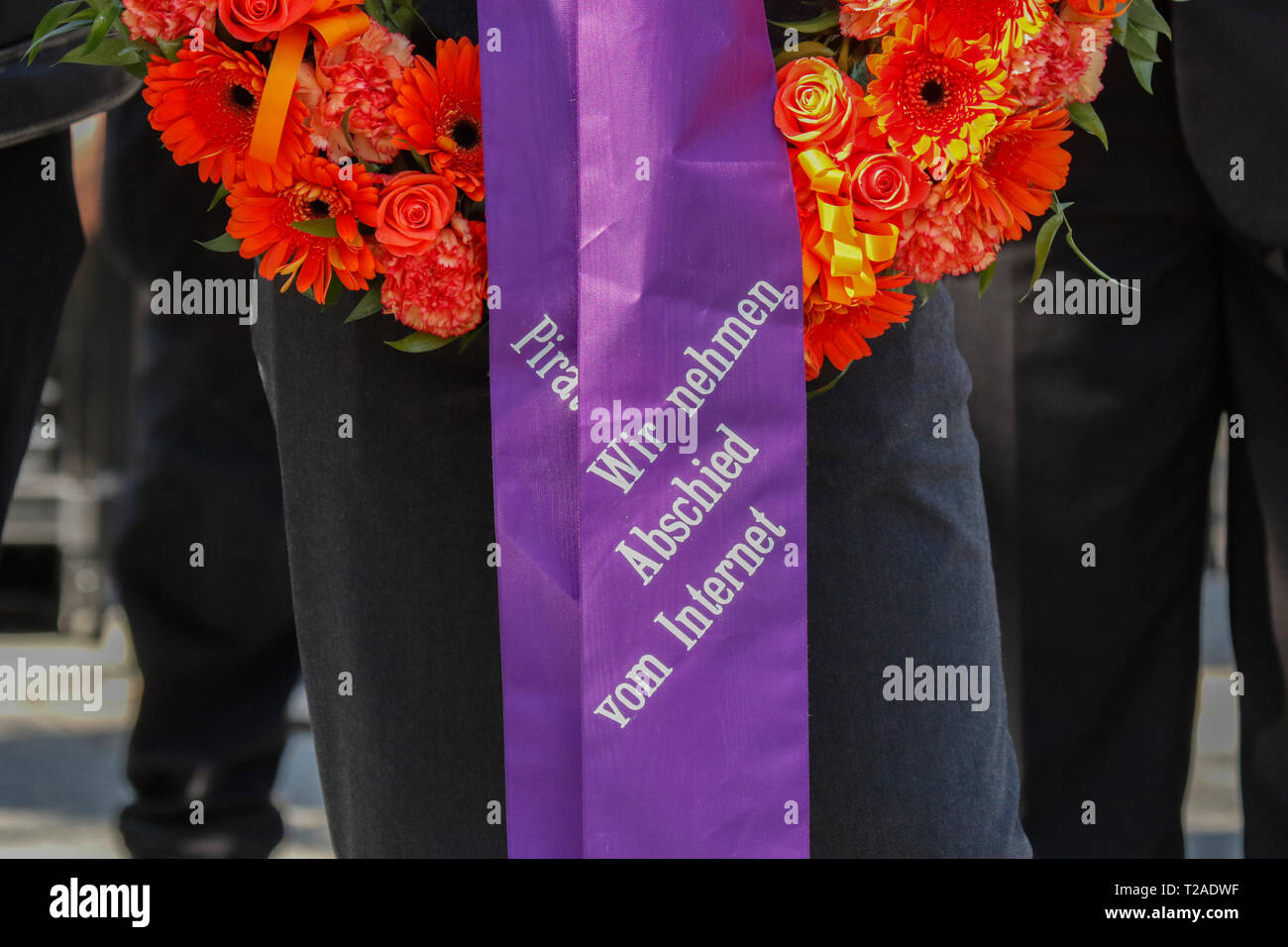 Frankfurt, Germany. 30th Mar, 2019. A mourner carries a wreath that reads 'We say good-bye to the Internet'. Around 100 people marched through the centre of Frankfurt, to mourn the free Internet, after the EU Parliament has voted in favour of the EU Copyright Directive. They were carrying a coffin and were reading eulogies to the Internet. Credit: Michael Debets/Pacific Press/Alamy Live News Stock Photo