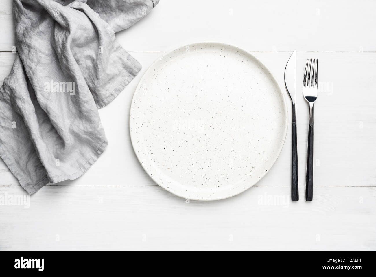 Empty plate, cutlery and linen textile. Table setting with copy space for text Stock Photo