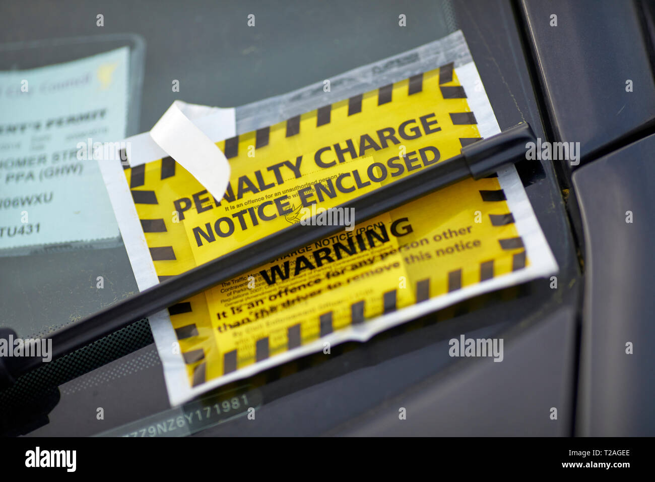 Yellow window sticker Penalty Charge Notice council parking fine attached to car windscreen  by Liverpool, Council Stock Photo