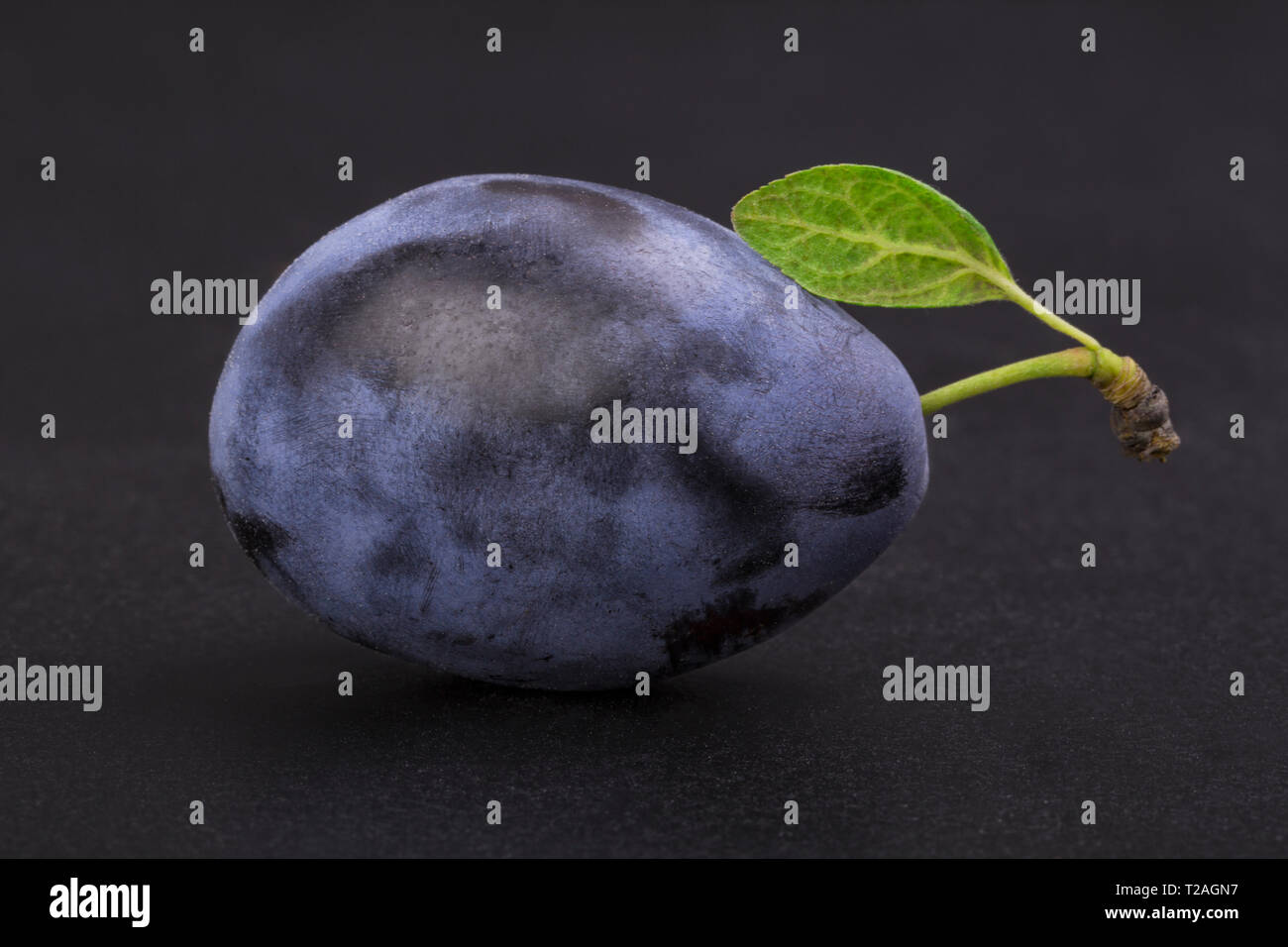 Ripe plum with a green leaf isolated on a black background Stock Photo ...