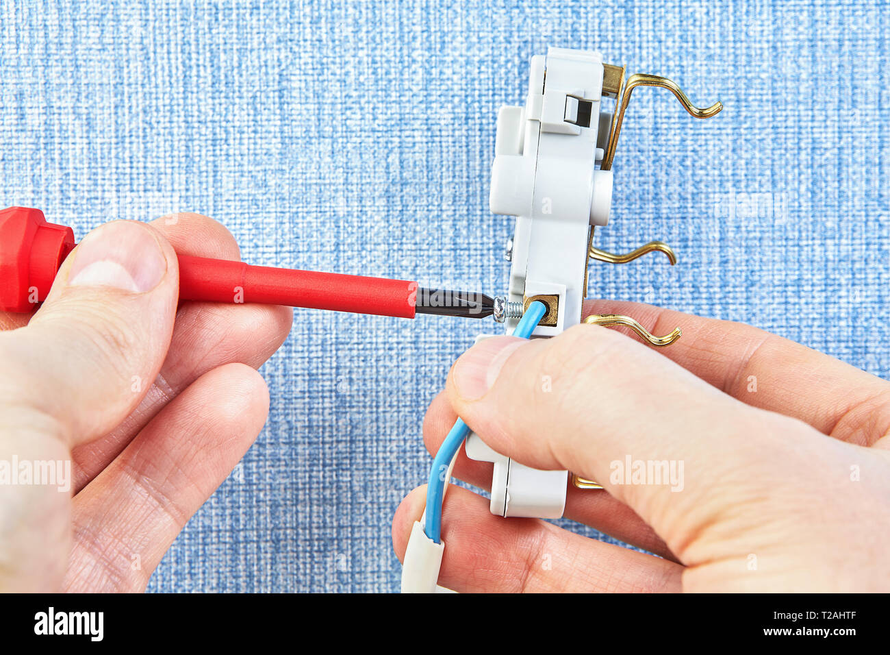 Mounting electrical wall socket by electrician with screwdriver, close-up. Stock Photo