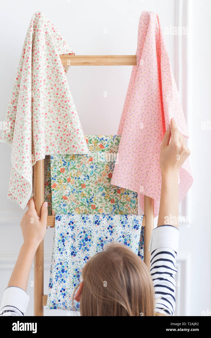 Woman choosing fabric from rack Stock Photo