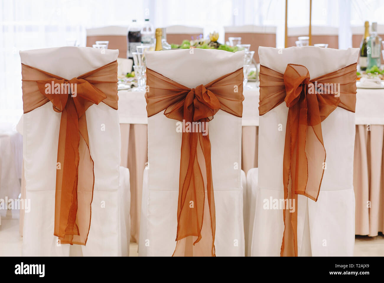 Ribbon tied to dining chairs at wedding Stock Photo