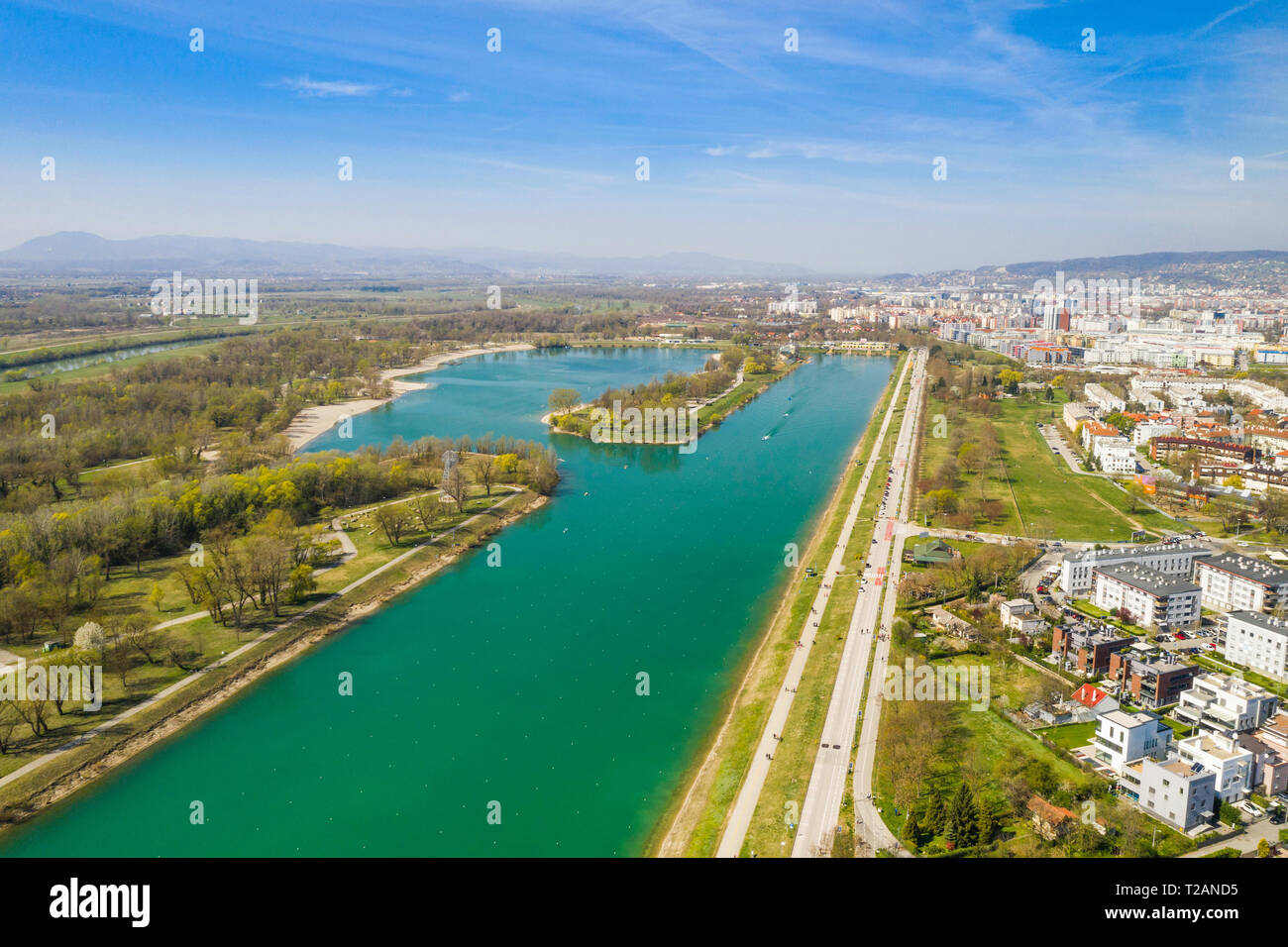 Zagreb, Croatia, Jarun lake, beautiful green recreation park area, sunny spring day, panoramic view from drone, city in background Stock Photo