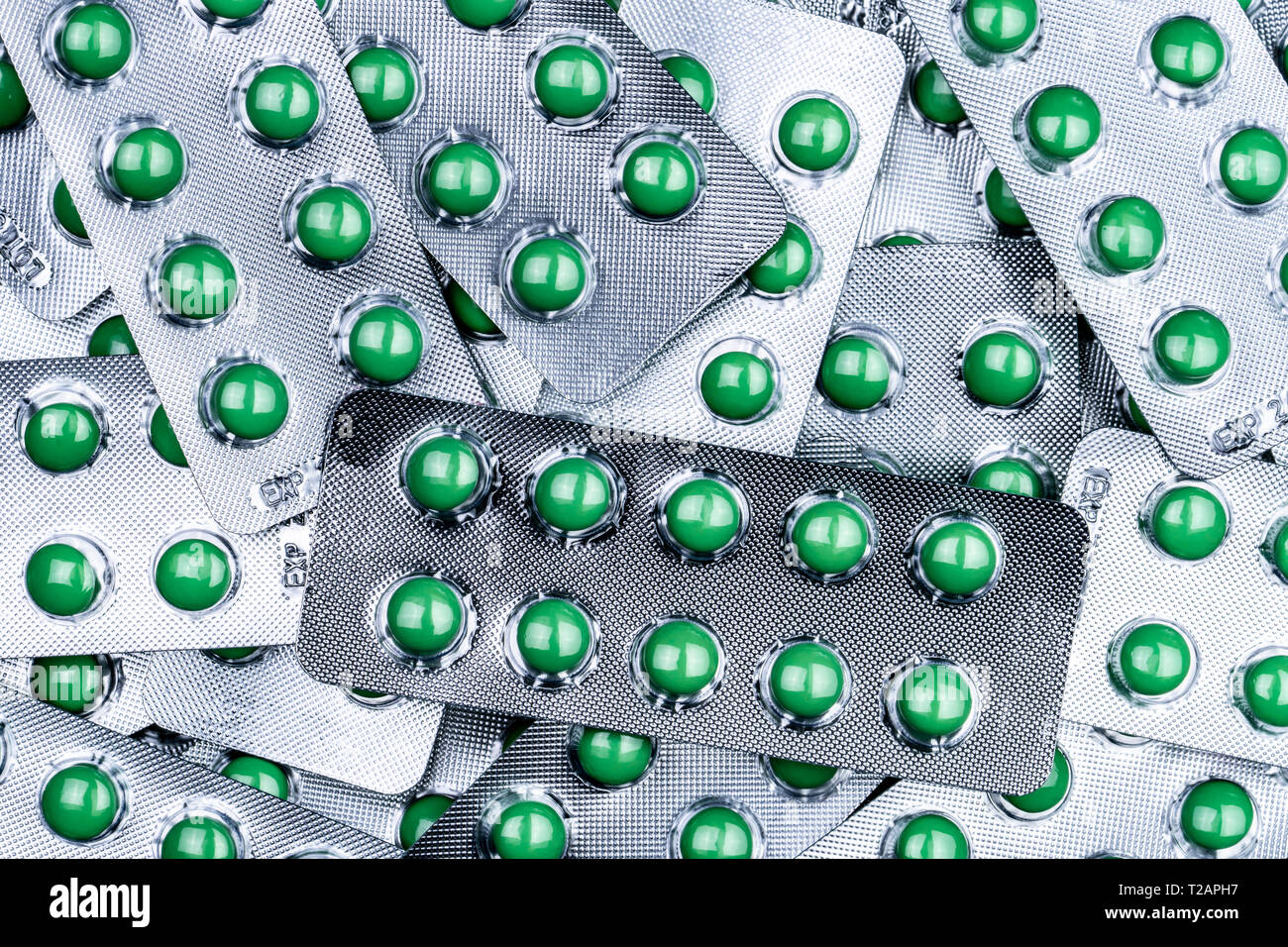 Closeup pile of round green sugar coated tablet pill in blister pack. Combine pill for relief cough. Pharmaceutical product. Pharmaceutical industry.  Stock Photo