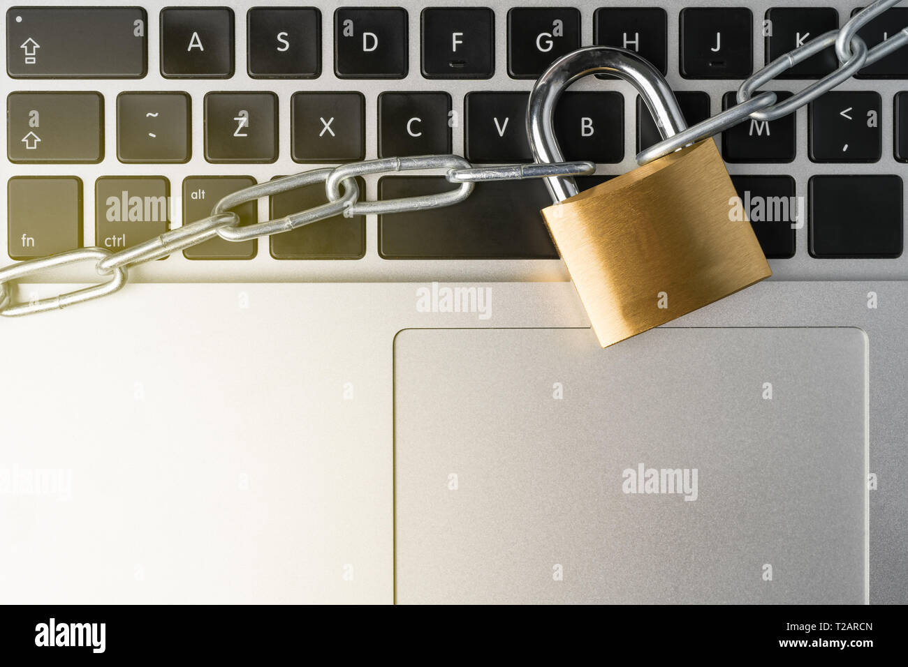 Padlock with chain on a laptop computer keyboard. Cyber security abstract concept. Stock Photo
