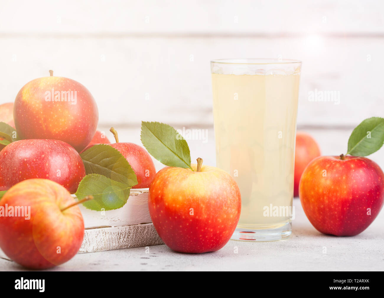 Glass of fresh organic apple juice with braeburn pink lady apples in