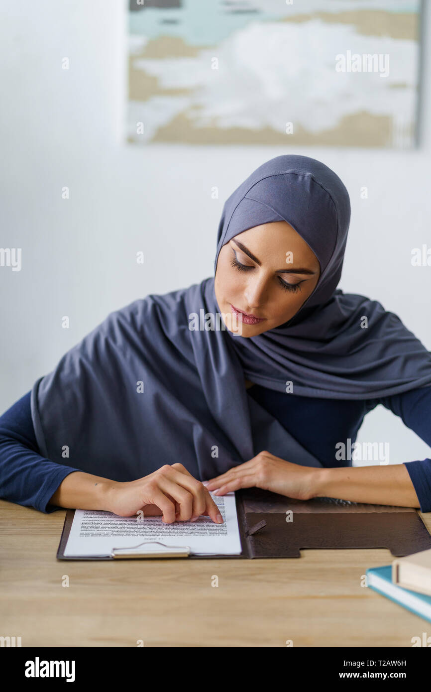 Muslim woman reading documents Stock Photo