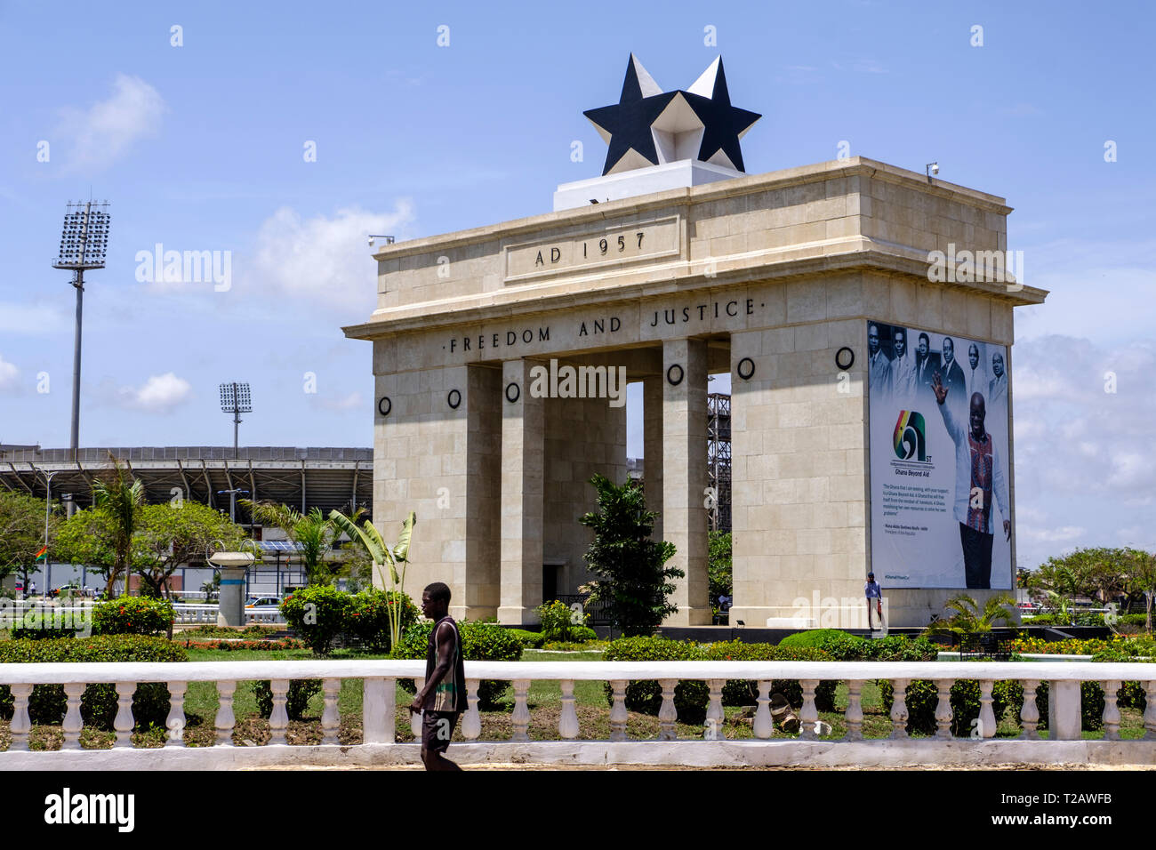 ACCRA,GHANA - APRIL 11 2018: Unidentified black man walks past arch of Black Star Gate Monument, symbol of freedom and part of Independence Square Stock Photo