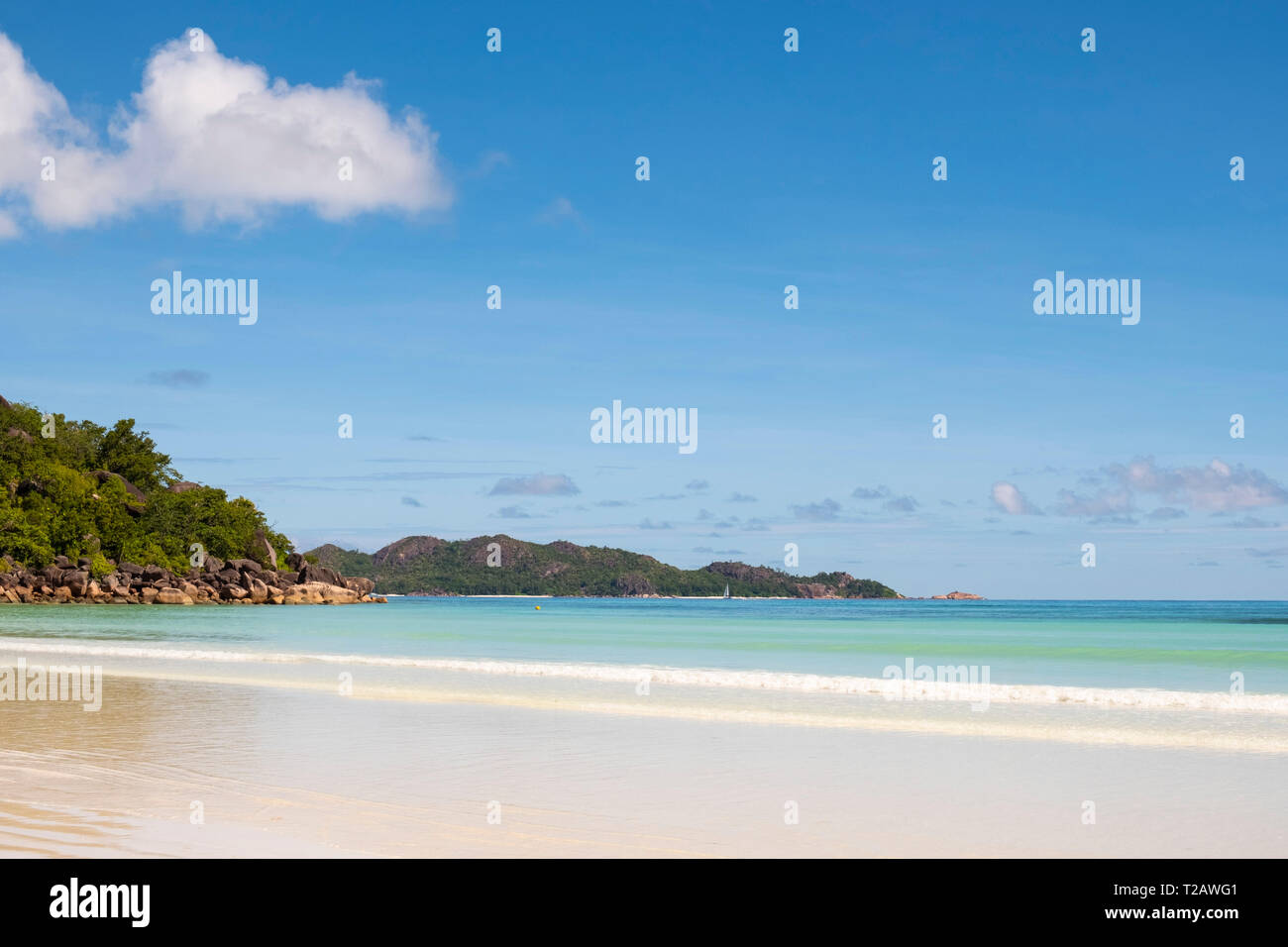 Calm sea on Anse Volbert and a view toward Curieuse Island from Praslin, the Seychelles Stock Photo