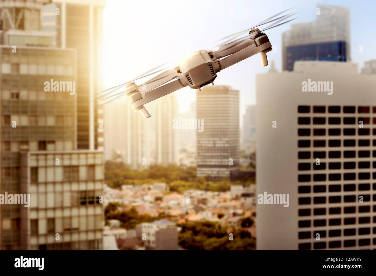 White drone with camera flying above modern city with skyscrapers and ...