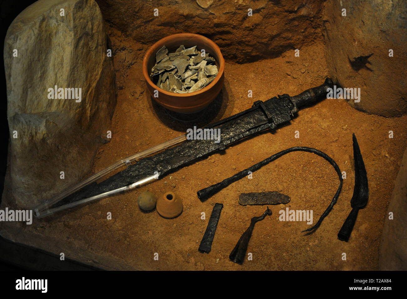 Celtic peoples. 3rd century BC. Recreation of a grave with stela. Burial pit possibly of a warrior chief for the objects of his funerary grave goods: an iron sword with damascene silver decoration, a banner auction, a razor and a tweezer. National Archaeological Museum. Madrid, Spain. Stock Photo