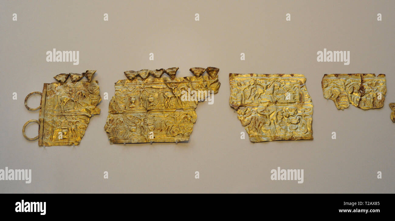 Diadem-belt from Mones. 3rd-1st centuries BC. Gold. Castro Culture. Depicts, in an aquatic landscape, figures carrying cauldrons and riders with torques-rattles and shields or daggers, depicting the transit to the alterlife. On the left, original fragments. On the right, replica fragments from the Museum of National Archeology and National Domain of Saint-Germain-en-Laye, and from the Instituto Valencia de Don Juan (Madrid). From Mones (Pilona, Asturias, Spain). National Archaeological Museum. Madrid. Spain. Stock Photo