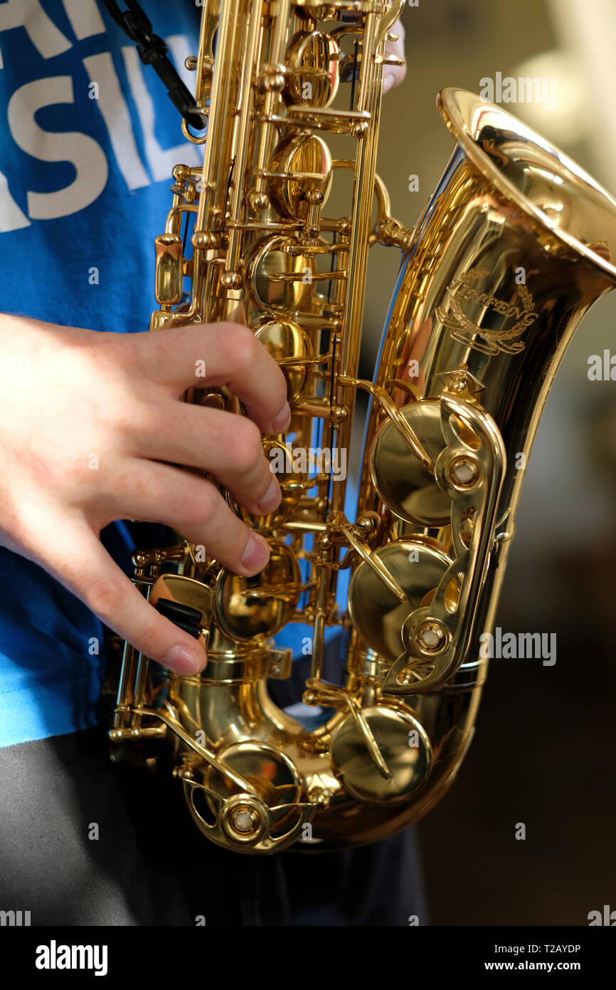 Young Man Plays Mini Saxophone with Bare Hands Stock Photo - Image