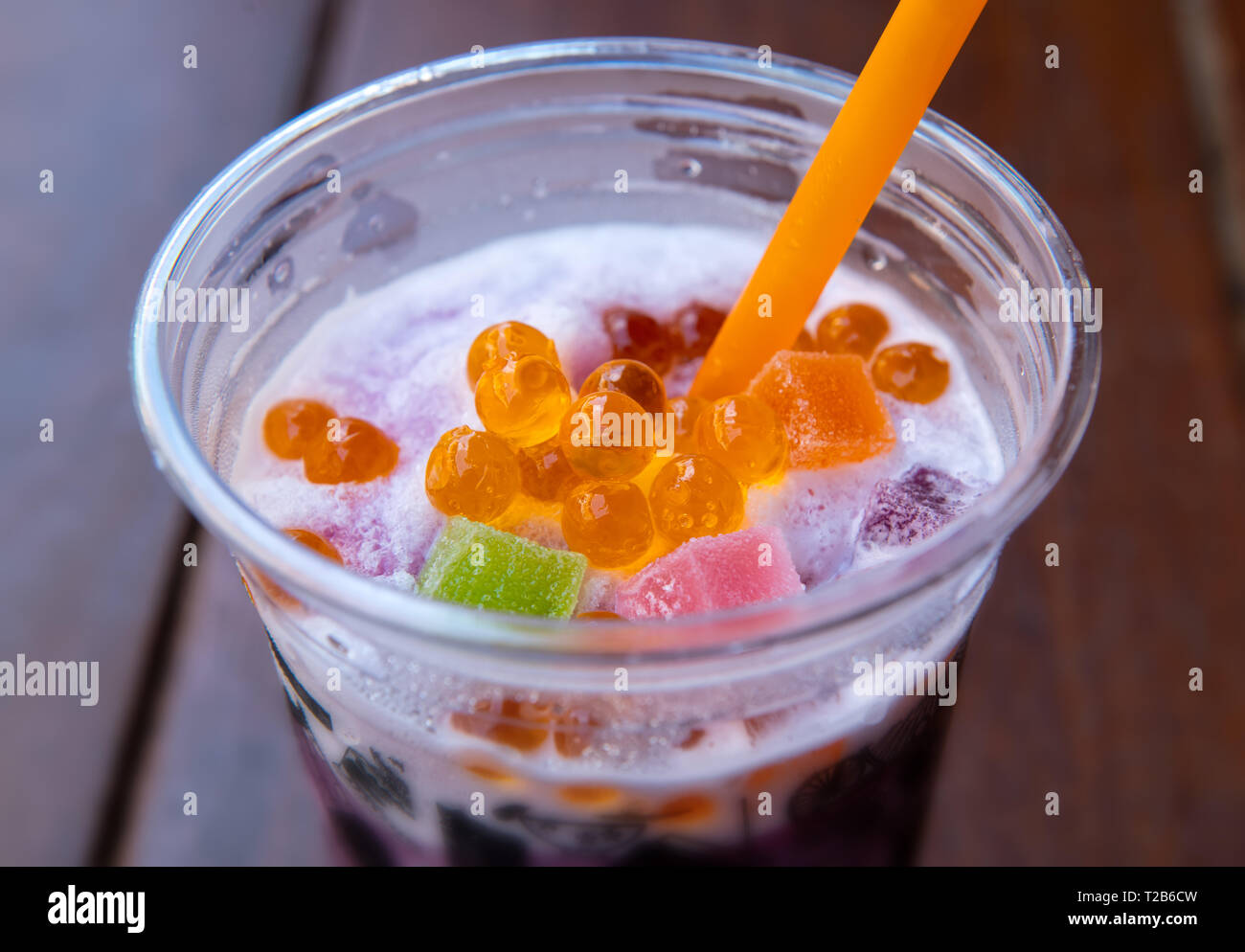 Sweet soda smoothie with fruit and colorful jelly topping in outdoor sun lighting. Stock Photo