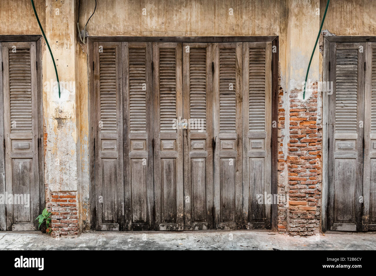 Wooden doors of ancient house in old town village for tourism in Thailand. Stock Photo
