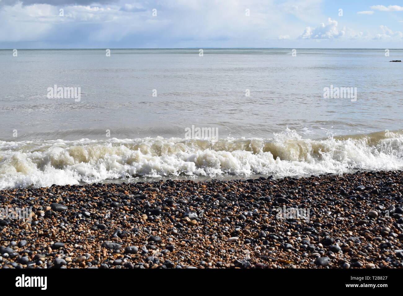 Sea Scene, Dramatic cloudy sky over Saint Margaret's bay with sea water coming up on to the pebble beach Stock Photo