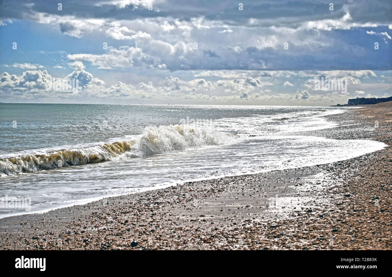 Sea scene waves crashing onto the pebble beach Stock Photo