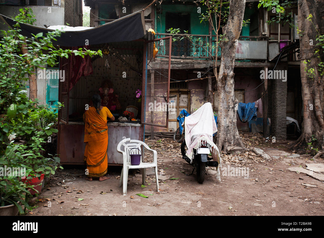 Woman praying to lord Ganesha near old building in Wadas of Pune, India. Stock Photo