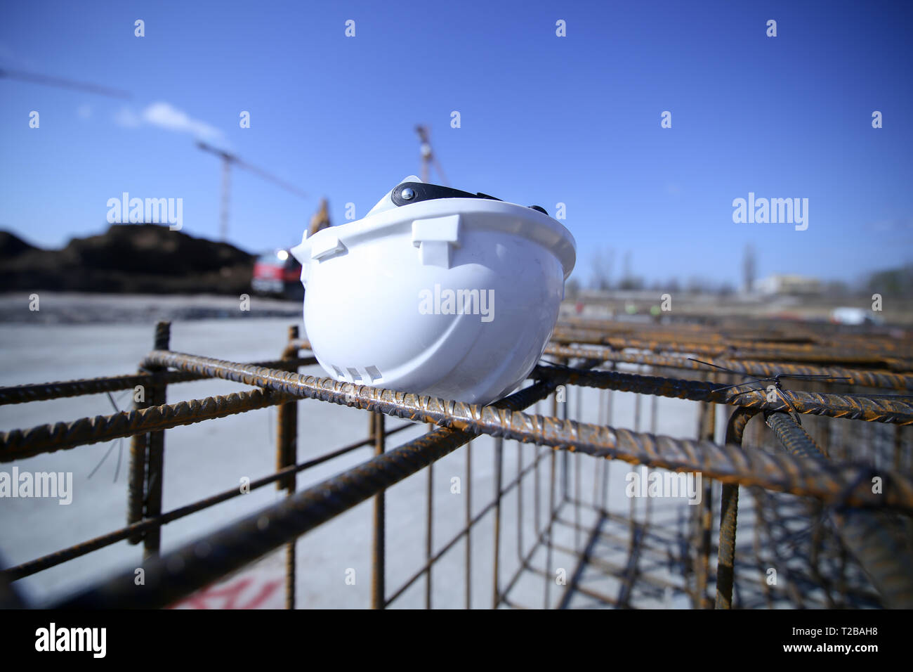 Construction worker helmet on top of a reinforcing iron on a construction site Stock Photo