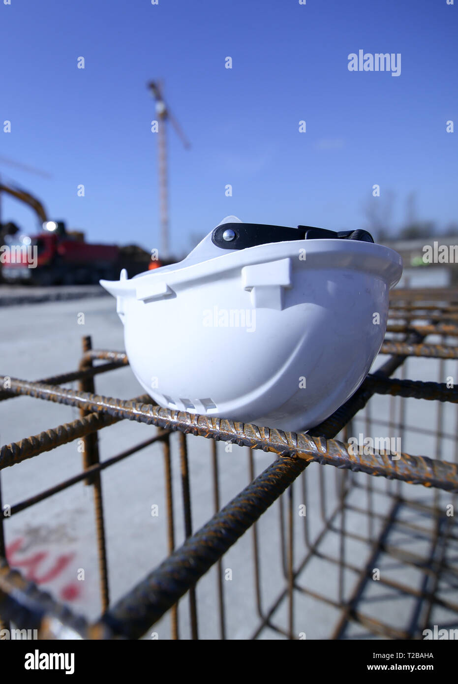 Construction worker helmet on top of a reinforcing iron on a construction site Stock Photo