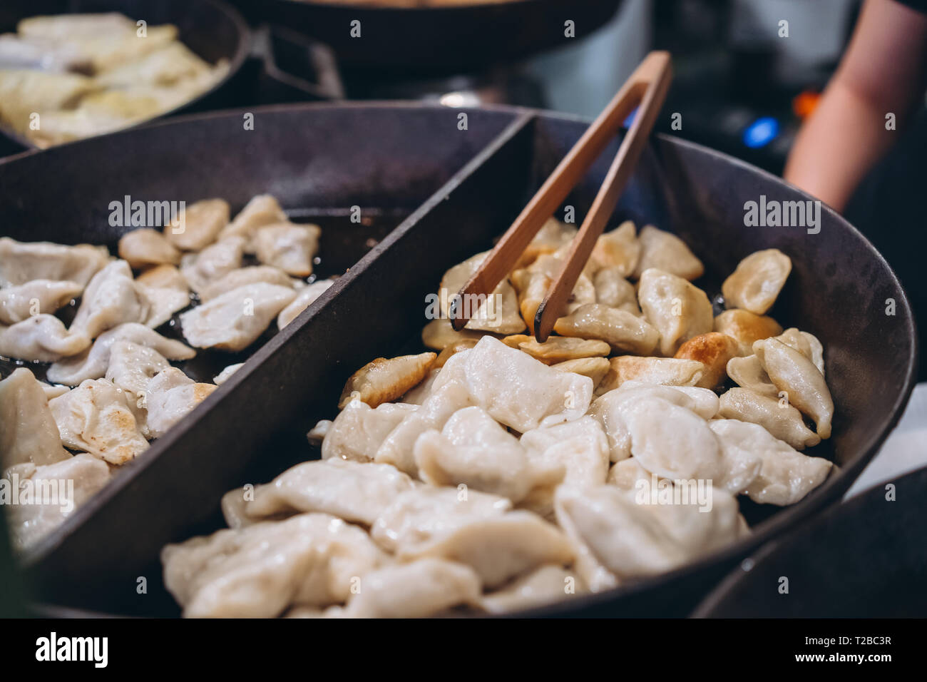 Dumplings with meat, onions on a big cast iron skillet. Close angle