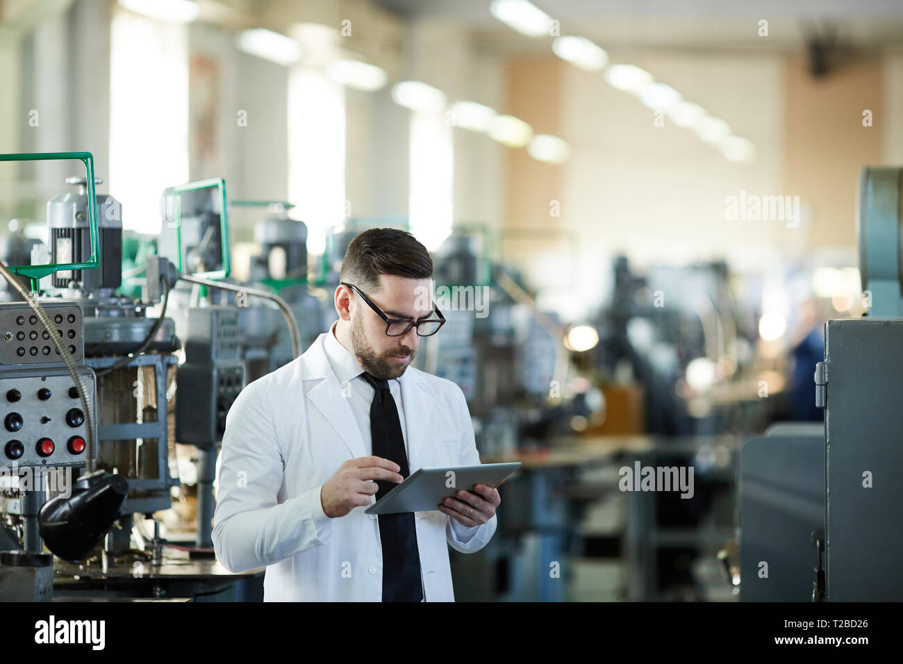 Handsome Factory Manager Using Tablet Stock Photo