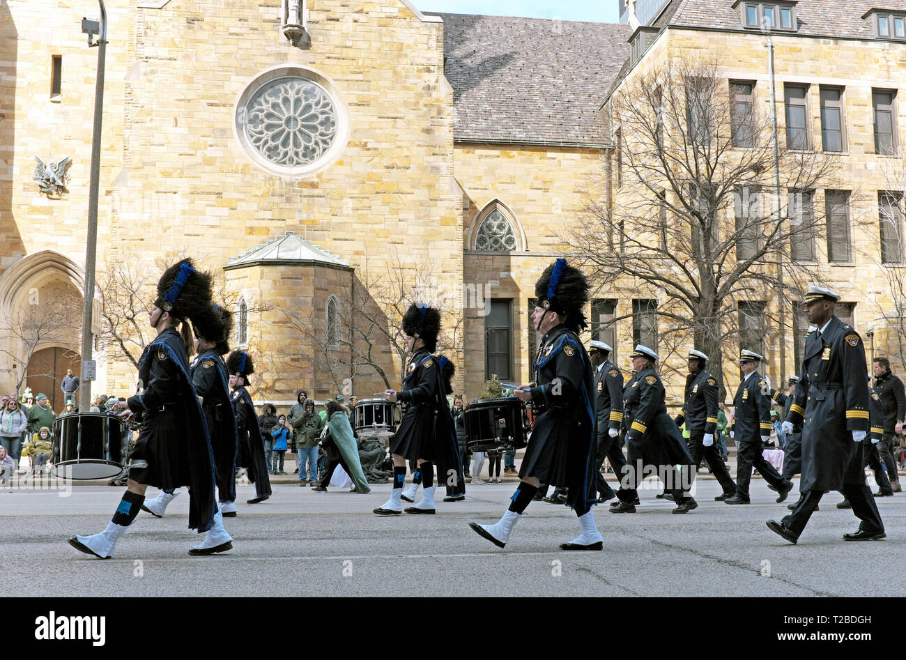Kilt-wearing performers in the 2019 St. Patrick's Day Parade in Cleveland, Ohio march down Superior Avenue past St. John the Evangelist Cathedral. Stock Photo