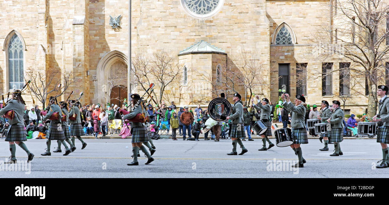 Kilt-wearing performers in the 2019 St. Patrick's Day Parade in Cleveland, Ohio march down Superior Avenue past St. John the Evangelist Cathedral. Stock Photo