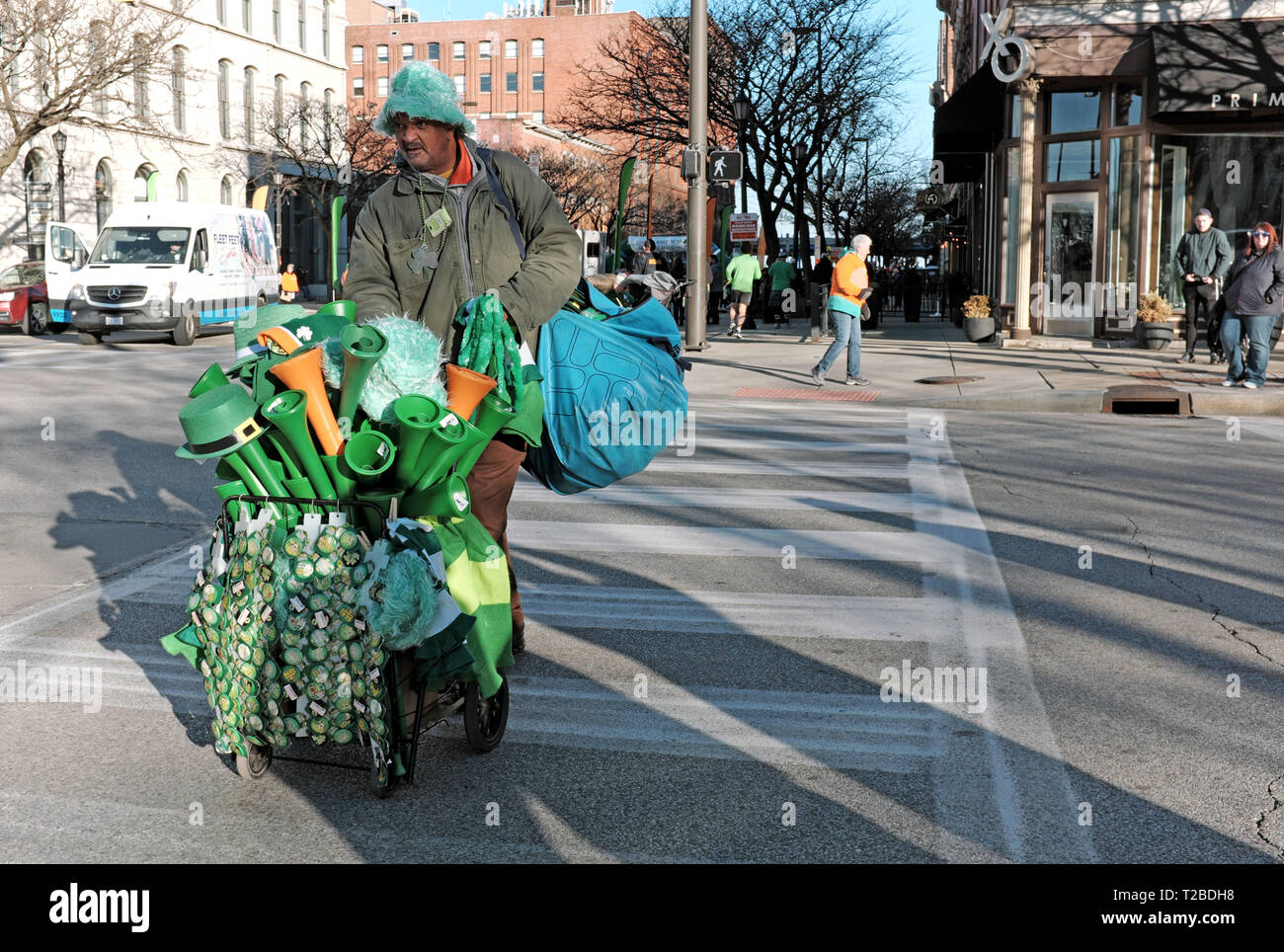 An early morning street merchant carts his 2019 St. Patrick's Day merchandise through downtown Cleveland, Ohio prior to the all day celebration. Stock Photo
