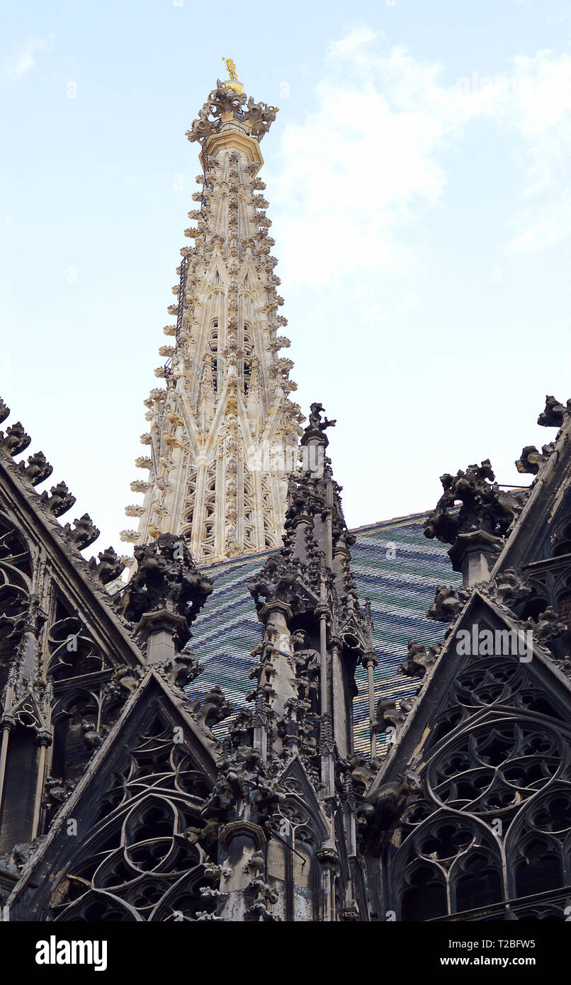 The magnificent south tower of the Stephansdom (St Stephen;s cathedal) rises above gothic tracery and the mosaic tiled roof in Vienna, Austria Stock Photo