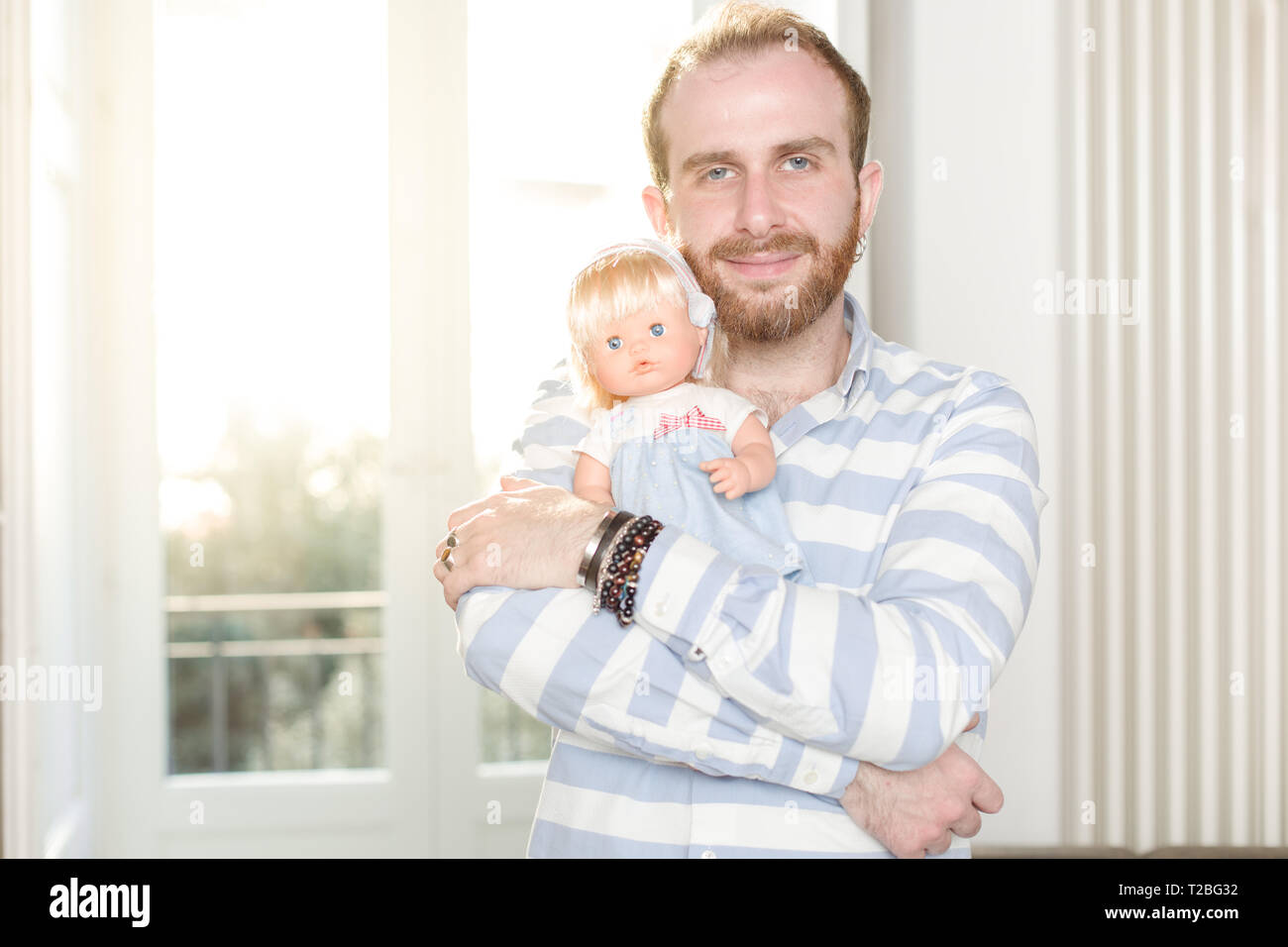Smiling Redhead Man with Beard  Hugging a Doll Stock Photo