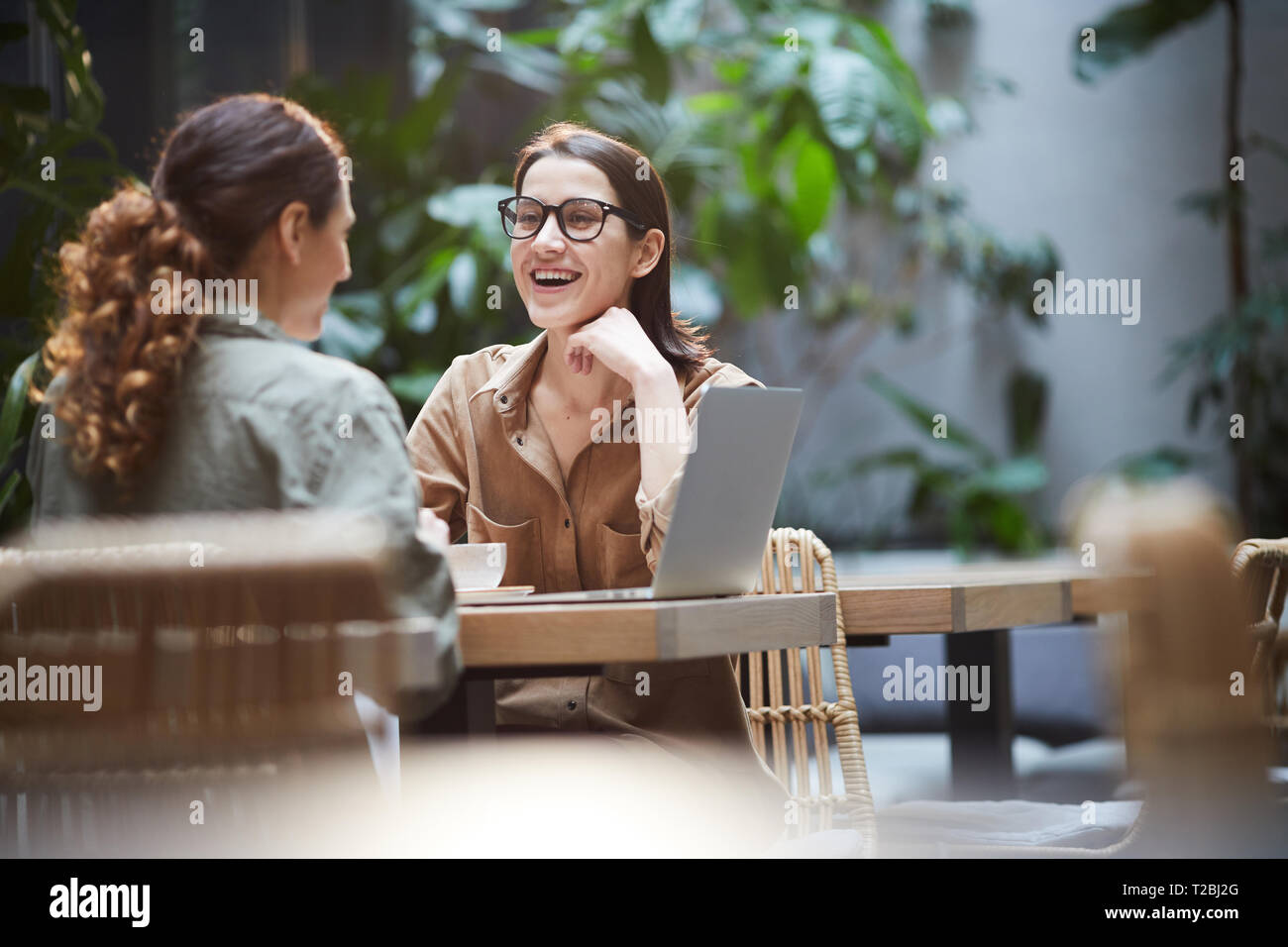 Woman laughing during lunch with colleague Stock Photo - Alamy