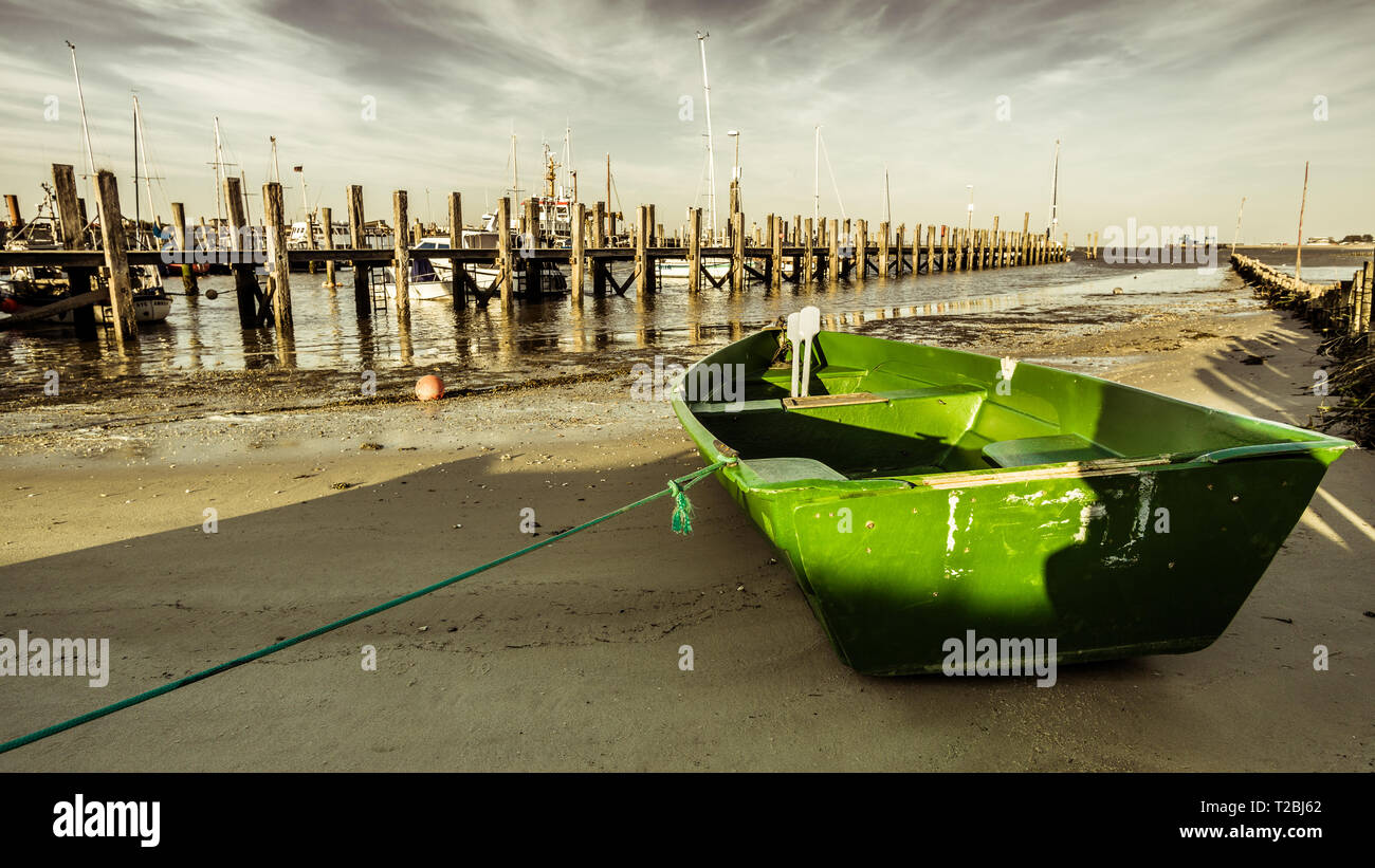 a little green boat in a little harbour on Amrum, a little island in the north sea near Sylt Stock Photo