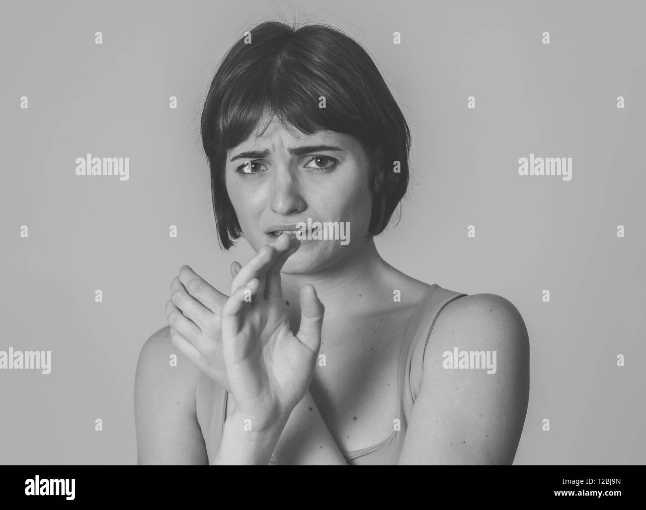Black and white close up of young woman feeling scared and shocked making fear, anxiety gestures. Looking terrified and desperate. With copy space. Pe Stock Photo