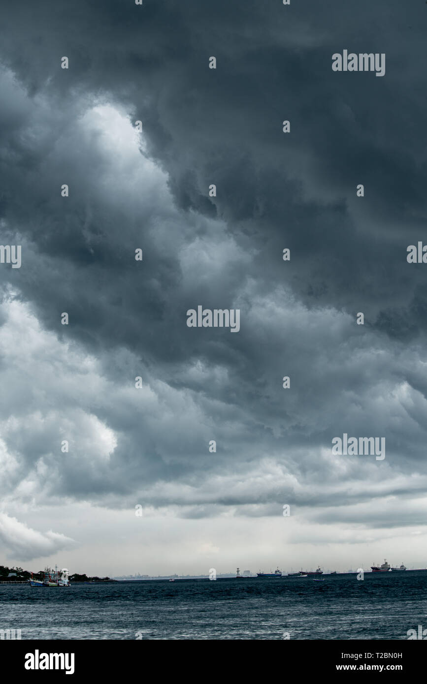 storm cloud background during raining. Dark Clouds. Huge black clouds on dark sky before a thunder-storm. Stock Photo