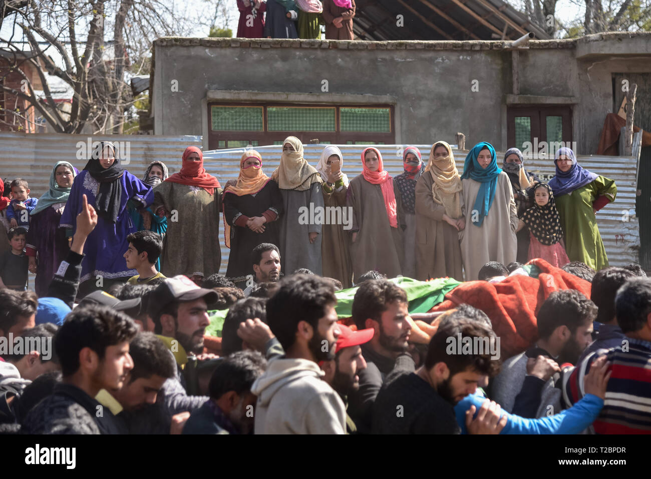 (EDITORS NOTE: Image depicts death) Kashmiri women are seen looking the dead body of the slain militant Aqib Ahmed Kumar being carried by Kashmiri men during his funeral procession at his residence in Shopian. According to reports four militants were killed in a gun battle with Indian security forces in Lassipora Pulwama some 50 Kms from summer capital Srinagar. Stock Photo