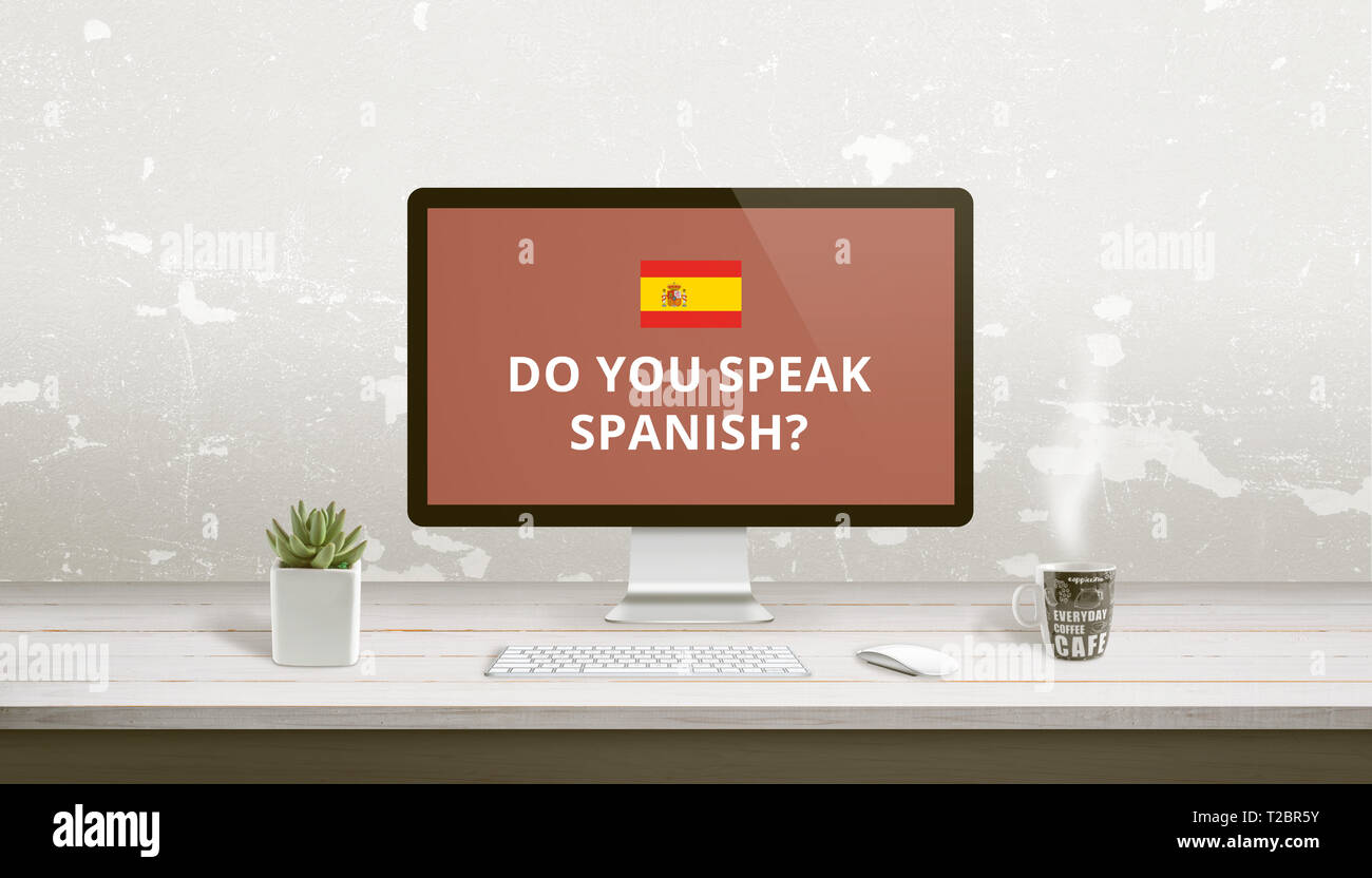 Concept of Spanish language learning online. Question Do you speak Spanish on a computer display on work desk. Stock Photo