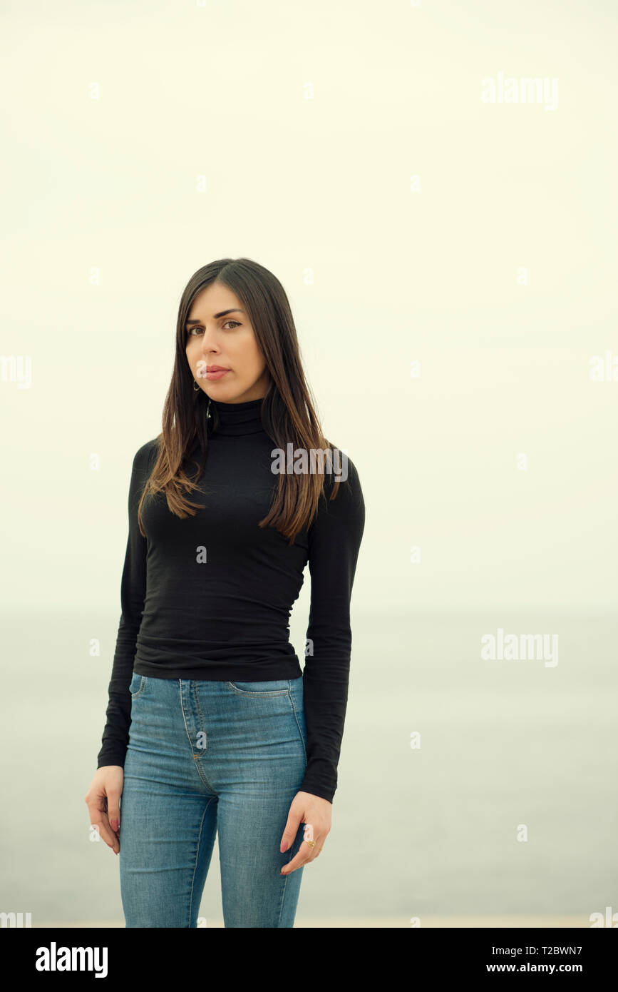 Beautiful young woman standing on the beach Stock Photo - Alamy