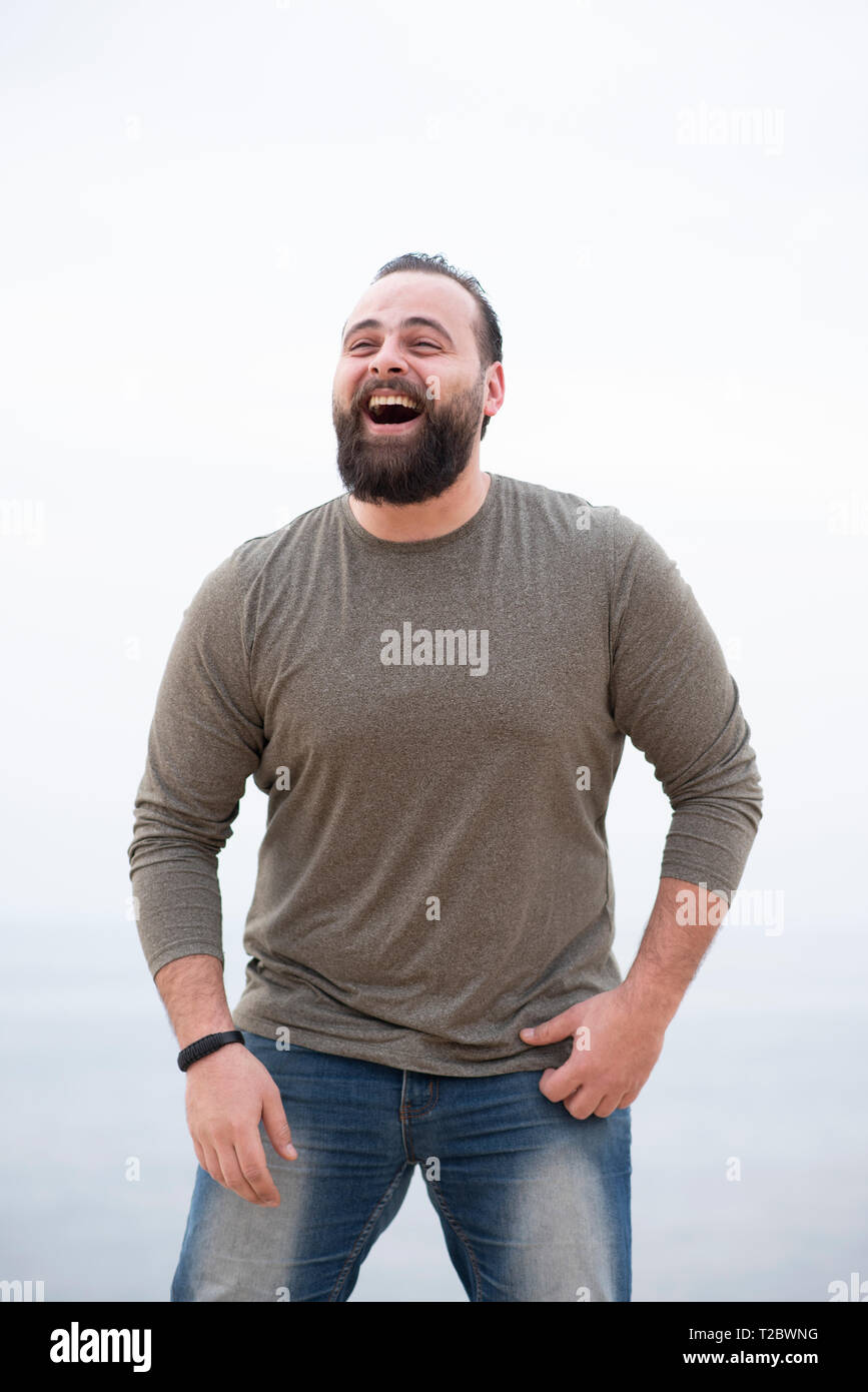 Big man laughing outdoors looking away Stock Photo - Alamy