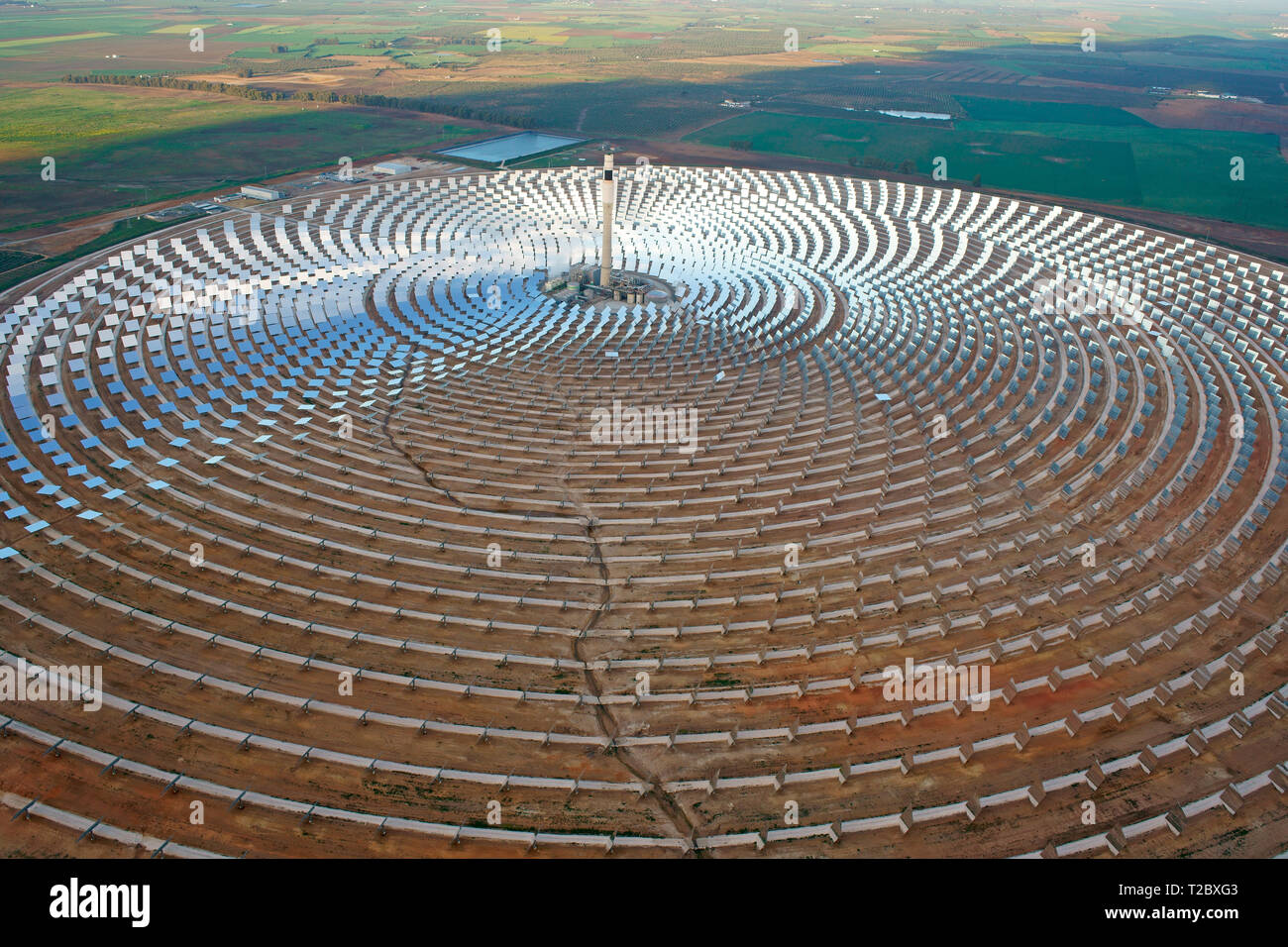 AERIAL VIEW. Field of heliostats and its heat collecting central tower. Gemasolar Thermasolar Plant, Fuentes de Andalucia, Andalusia, Spain. Stock Photo