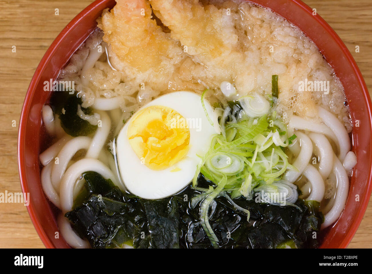 tempura udon with fried shrimps, boiled egg, green algae, leeks, tipical noodles traditional