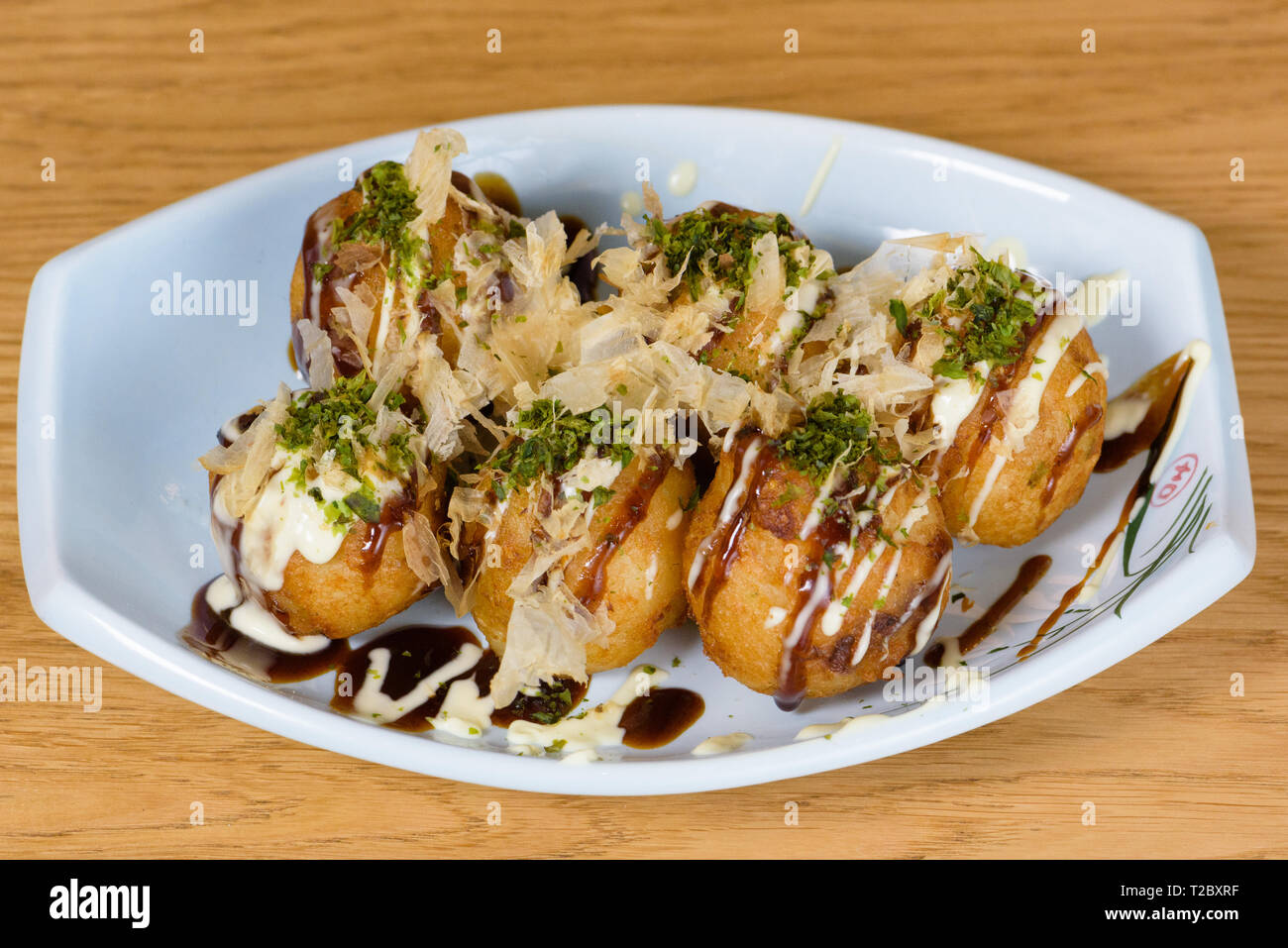 takoyaki, typical fried octopus meatballs, Osaka's culinary culture, garnished with cheese sauce, soy sauce and Katsuobushi, okaka, flakes of dried me Stock Photo