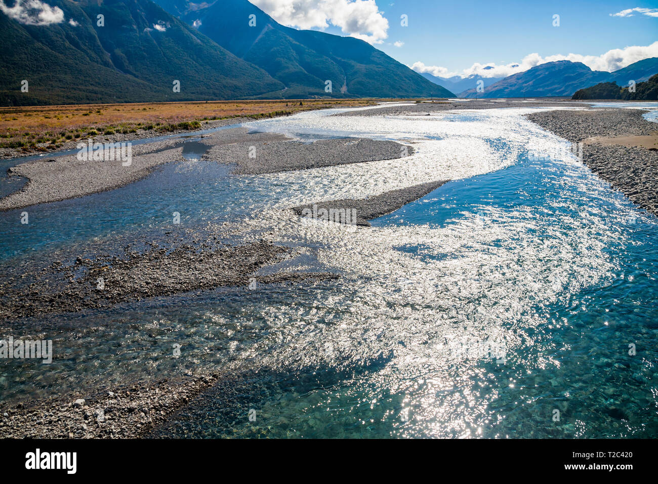 Sun reflecting in Waimakariri or Courtenay River, shallow braided river that flows from the Southern Alps across the Canterbury Plains to the Pacific  Stock Photo