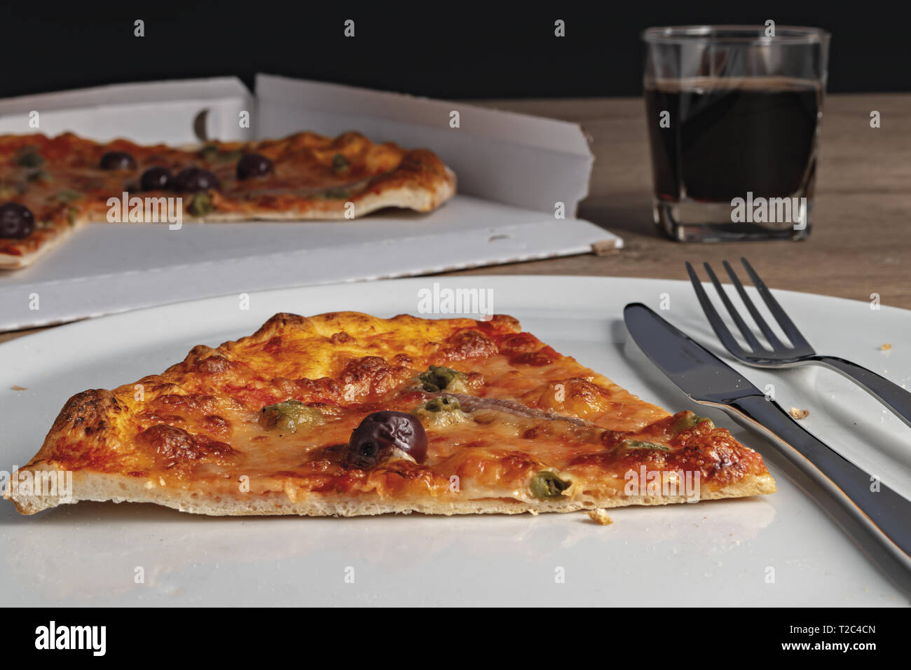 pizza pomodoro acciughe capperi olive nere fetta nel piatto dal basso Stock Photo