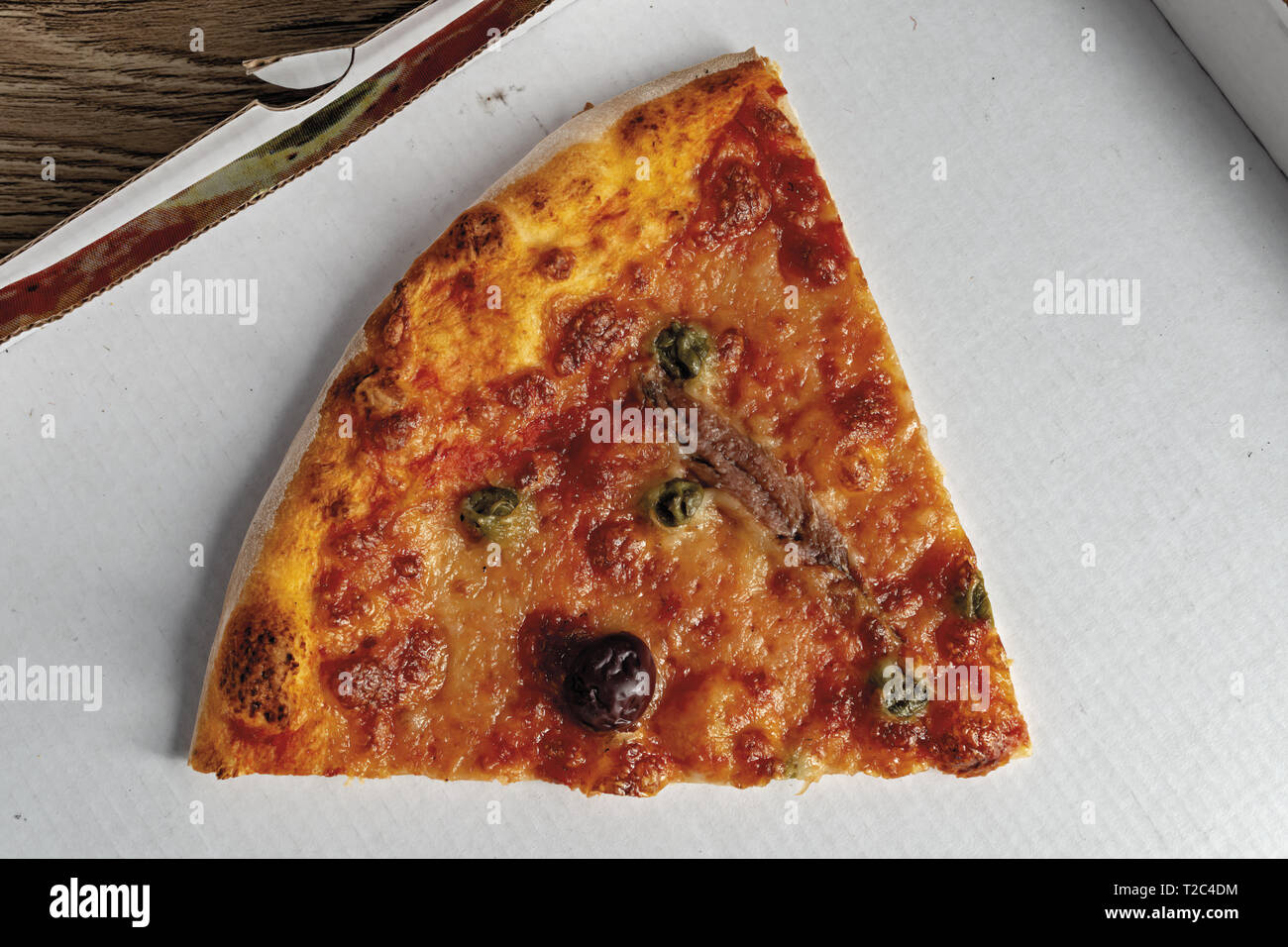 pizza pomodoro acciughe capperi olive nere fetta dall'alto nella scatola primo piano Stock Photo