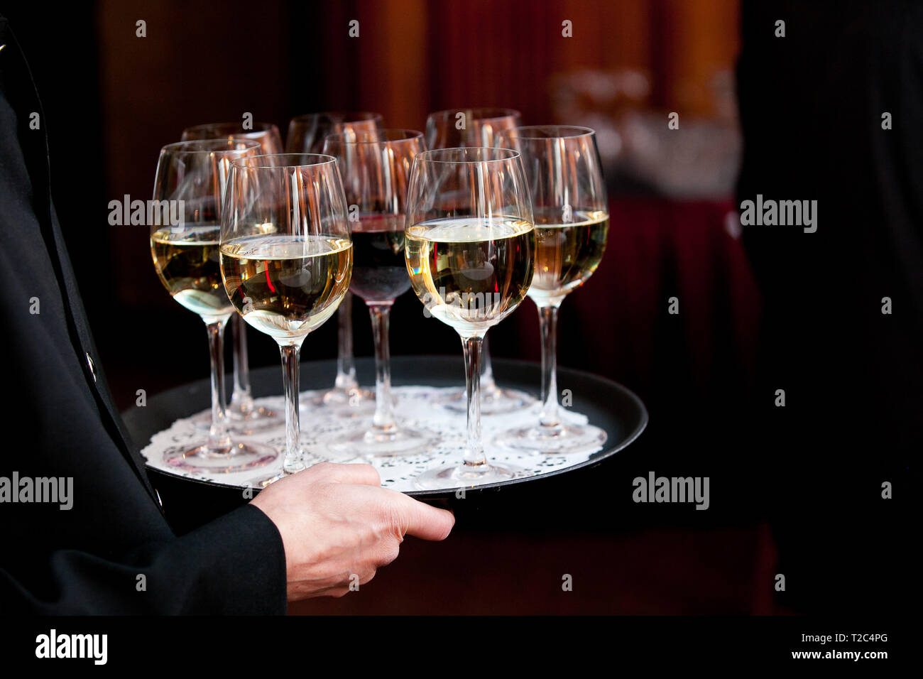 A waiter holding a tray full of drinks during a catered wedding or other special event Stock Photo