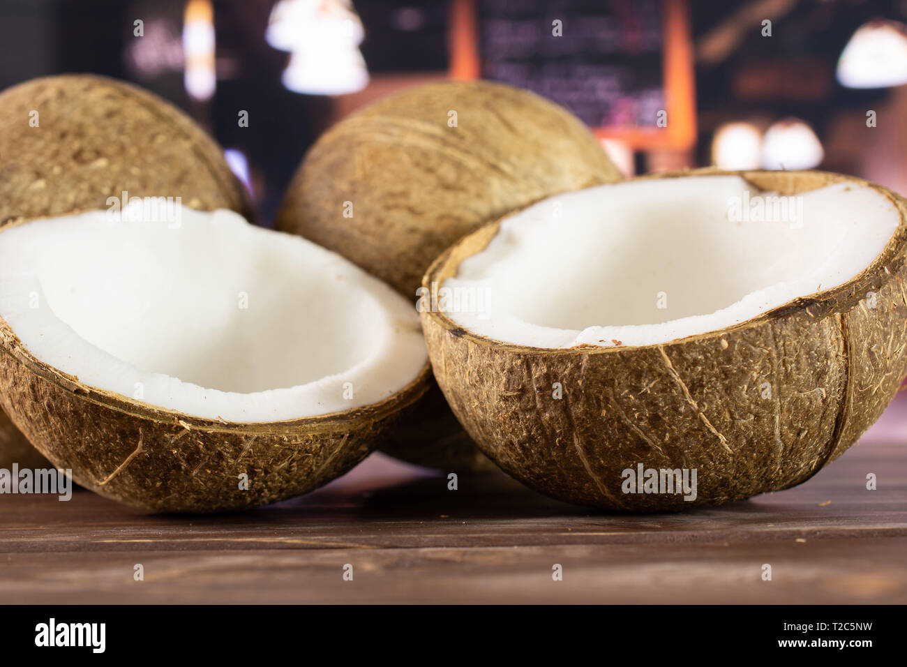 Group of two whole two halves of fresh bio coconut in a restaurant